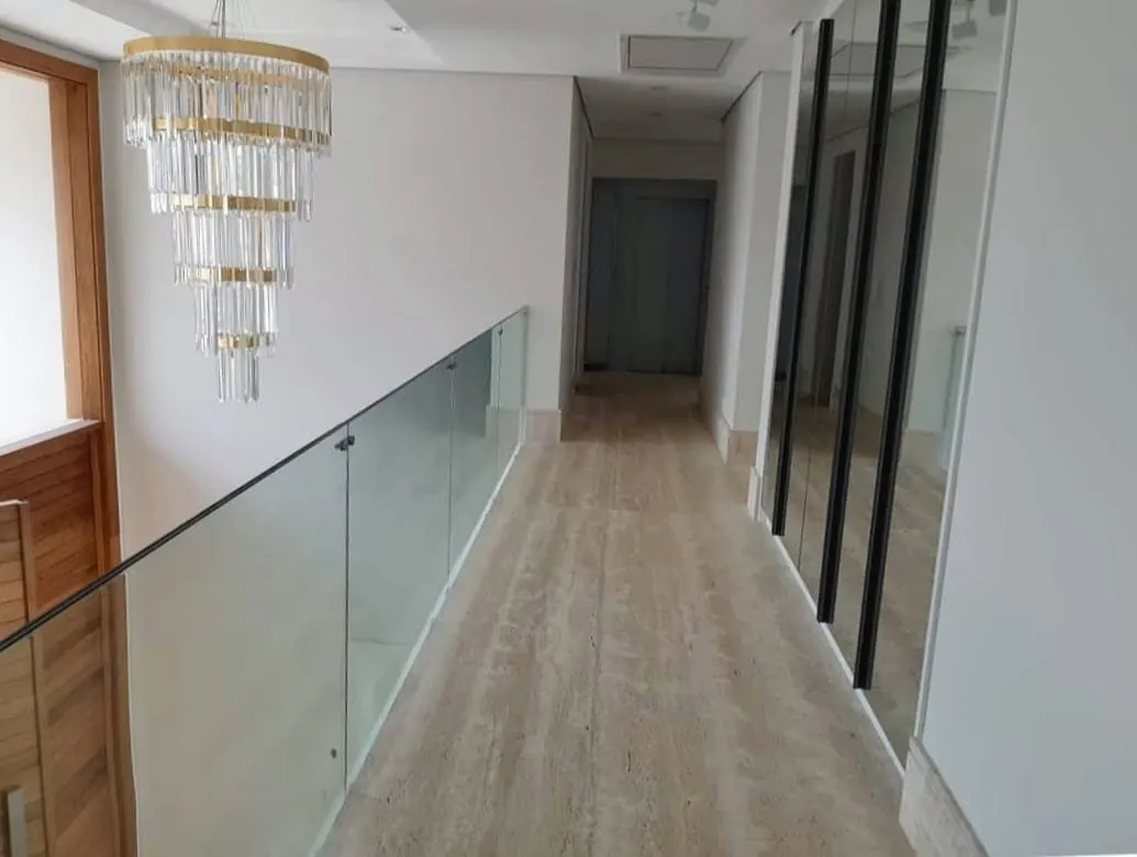 Corredor com piso de travertino polido e lustre